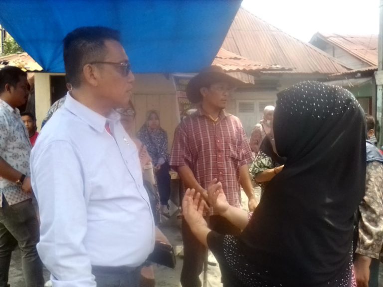 Ketua Fraksi PAN DPRD Kota Medan, Edwin Sugesti Nasution saat berbau bersama para korban kebakaran di Jalan Sentosa Lama, Kamis. (mimbar/jamal)