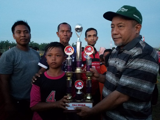 Ketua DPRK Aceh Tamiang Suprianto saat memberikan tropi pada pemenang turnamen sepakbola U-9 dan U-11 di Stadion Utama. (mimbar/burhan)