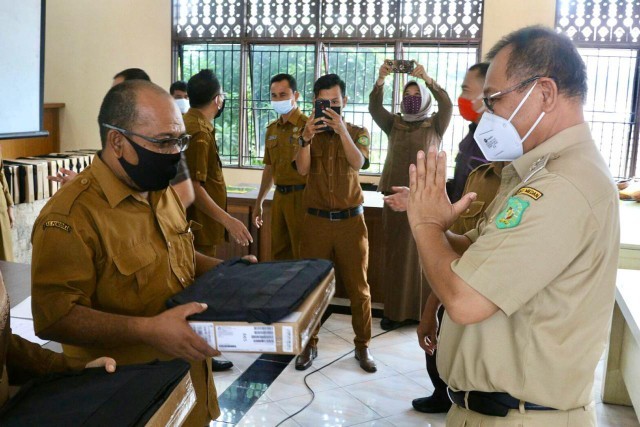 Plt Wali Kota Medan meyerahkan notebook kepada guru SD dan SMP. (mimbar/ist)