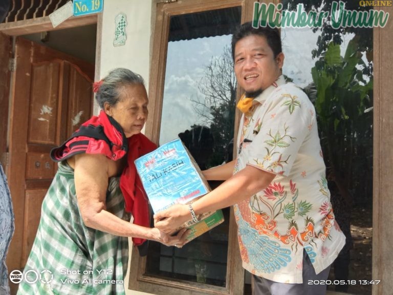 Teks foto : Tokoh Komunitas Anak Muhammadiyah juga kader DPP PAN, Amirullah Hidayat saat memberikan paket sembako ke warga. (djamaluddin)