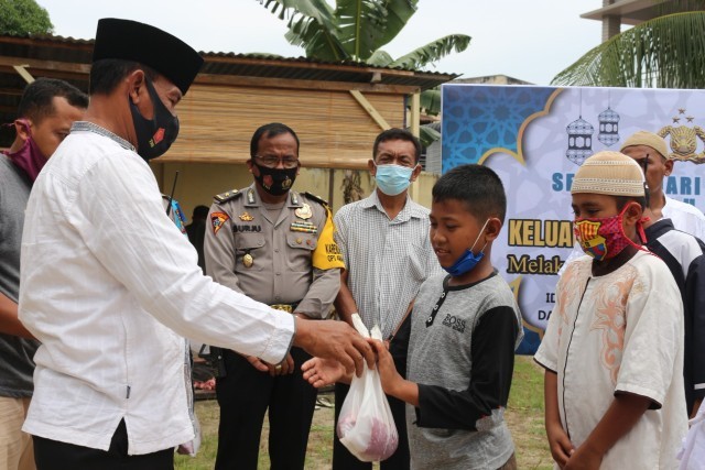 Kompol Sarponi memberikan daging qurban kepada anak yatim piatu. (mimbar/Ist)