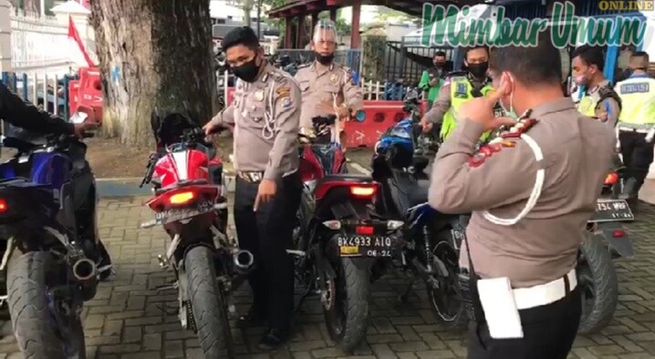 AKBP Sonny Siregar menutup telinganya lantaran suara knalpot dari sepeda motor bikin bising. (mimbar/dody ferdy)