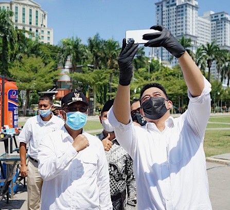 Bobby dan Akhyar foto bersama di Lapangan Merdeka usai membagikan masker. (ist)