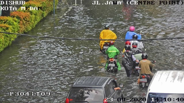 Rekaman kamera pengintai terlihat warga mendorong kendaraannya akibat banjir selutut di kawasan Jalan Jawa. (Ist)