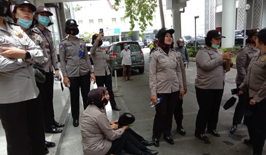 Polwan Polrestabes Medan terduduk di areal gedung dewan usai pelemparan batu yang mengenai lehernya. (djamaluddin)