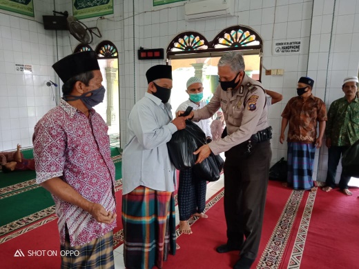 Personel Polsek Medan Area menyerahkan bantuan sembako pada pengurus Masjid Al Ikhlas. (mimbar/dody)