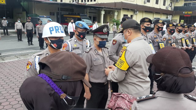 Kombes Pol Riko Sunarko menanggalkan pakaian dinas Polri dari personel saat upacara PDTH di Mapolrestabes Medan. (ist)