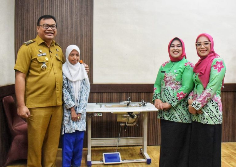 Bupati Asri Ludin Tmbunan menyerahkan bantuan mesin bordir kepada siswa ABK.